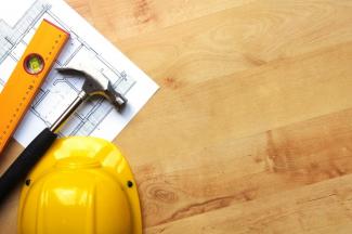 A hardhat, hammer, and contracting supplies