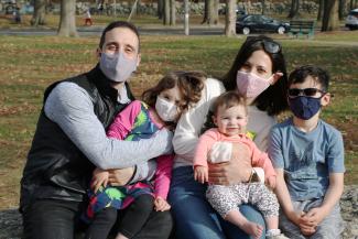A family with masks enjoying a day in a Providence park. 