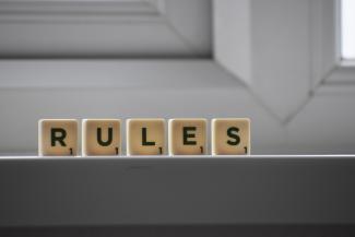 Scrabble tiles spell out "rules."