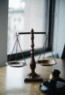 A judgment scale and gavel on an office desk. 