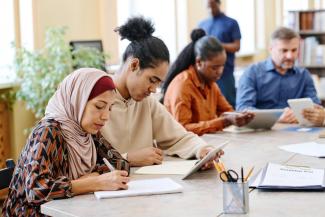 Multicultural people writing and taking notes
